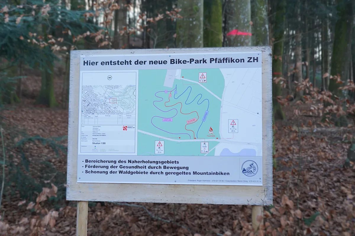 Blick auf ein Plakat, das den geplanten Bikepark zeigt. 